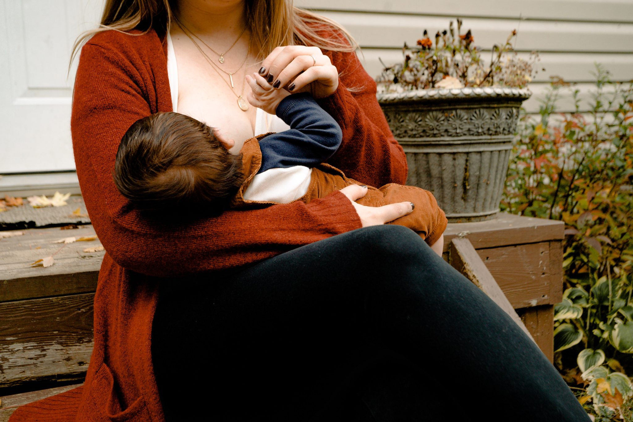 Mother sitting on bench breastfeeding her baby